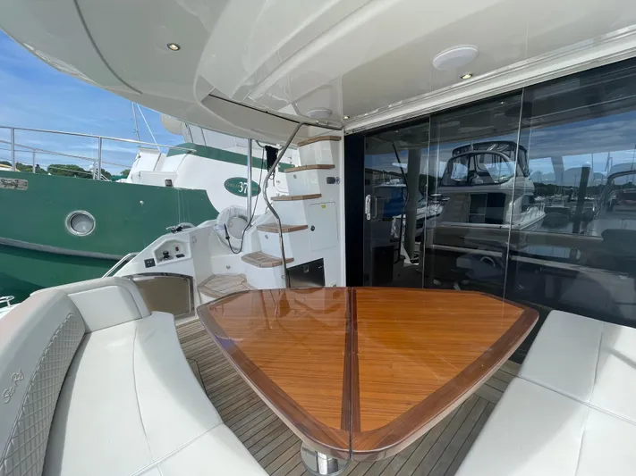 Kings' Ransom Yacht Photos Pics Luxurious 2017 Sea Ray L590 Fly yacht with elegant outdoor seating and wooden table.