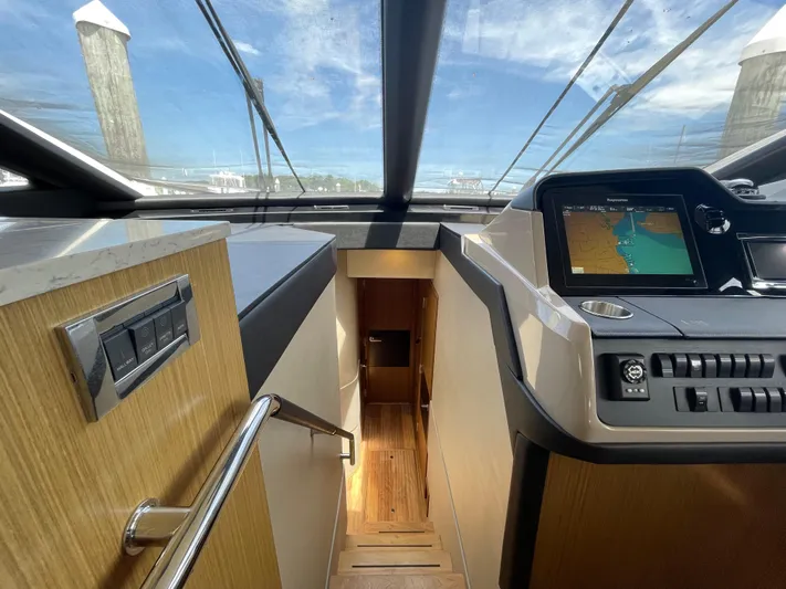 Kings' Ransom Yacht Photos Pics Interior view of 2017 Sea Ray L590 Fly yacht with navigation system and wooden stairs.
