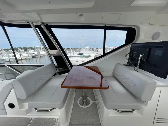 Kings' Ransom Yacht Photos Pics 2017 Sea Ray L590 Fly yacht interior with seating and table, overlooking marina.