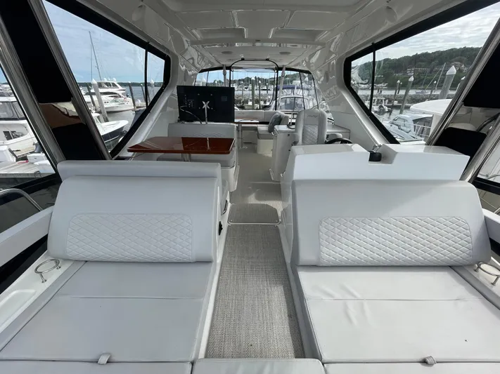 Kings' Ransom Yacht Photos Pics Luxurious interior of 2017 Sea Ray L590 Fly yacht with white seating and panoramic windows.