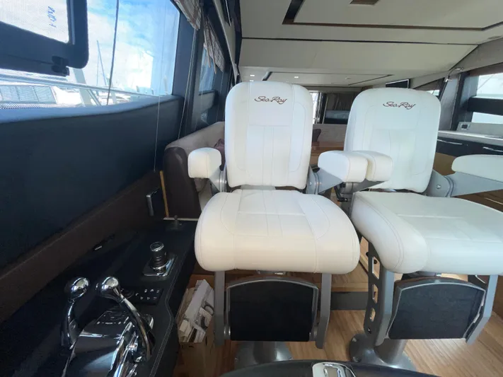 Kings' Ransom Yacht Photos Pics Interior of 2017 Sea Ray L590 Fly yacht with white captain chairs and control panel.