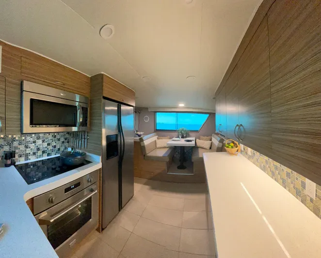 Fnfun Yacht Photos Pics Modern kitchen interior on 1989 Hatteras CPMY yacht with stainless appliances and dining nook.