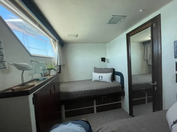 Fnfun Yacht Photos Pics 1989 Hatteras CPMY cabin interior with twin beds, window, and decorative accents.