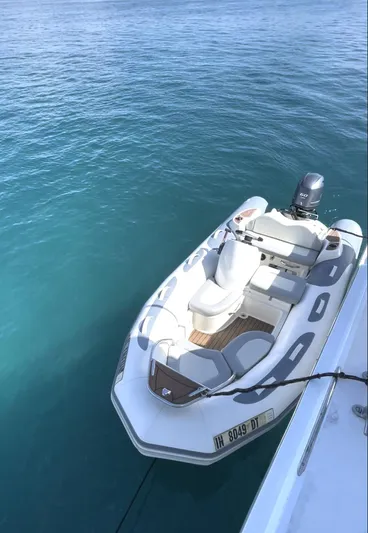 Fnfun Yacht Photos Pics Inflatable boat docked beside 1989 Hatteras CPMY yacht on clear blue water.