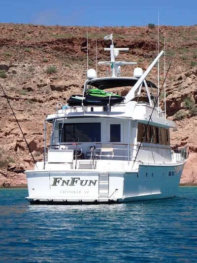 Fnfun Yacht Photos Pics 1989 Hatteras CPMY yacht anchored in clear blue water near rocky shoreline.