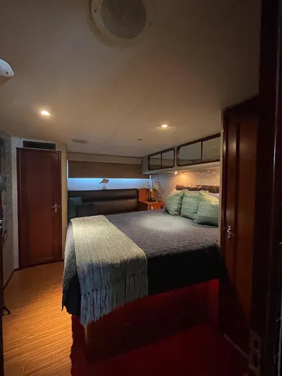 Fnfun Yacht Photos Pics Cozy bedroom in 1989 Hatteras CPMY yacht with elegant bedding and ambient lighting.