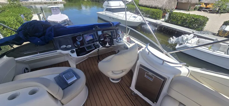  Yacht Photos Pics 2012 Meridian 341 Sedan yacht cockpit with modern controls and seating, docked near other boats.