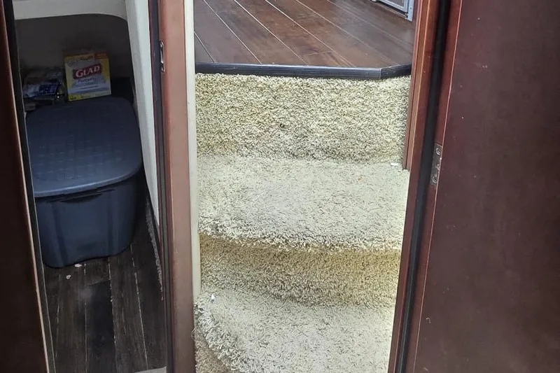  Yacht Photos Pics Carpeted stairs inside a 2012 Meridian 341 Sedan yacht, leading to a wooden floor area.