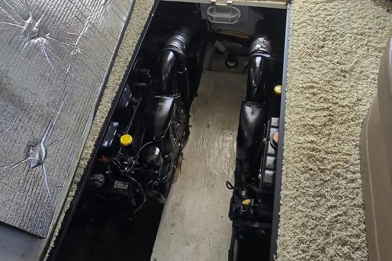  Yacht Photos Pics Engine compartment of a 2012 Meridian 341 Sedan, showcasing dual engines and carpeted flooring.