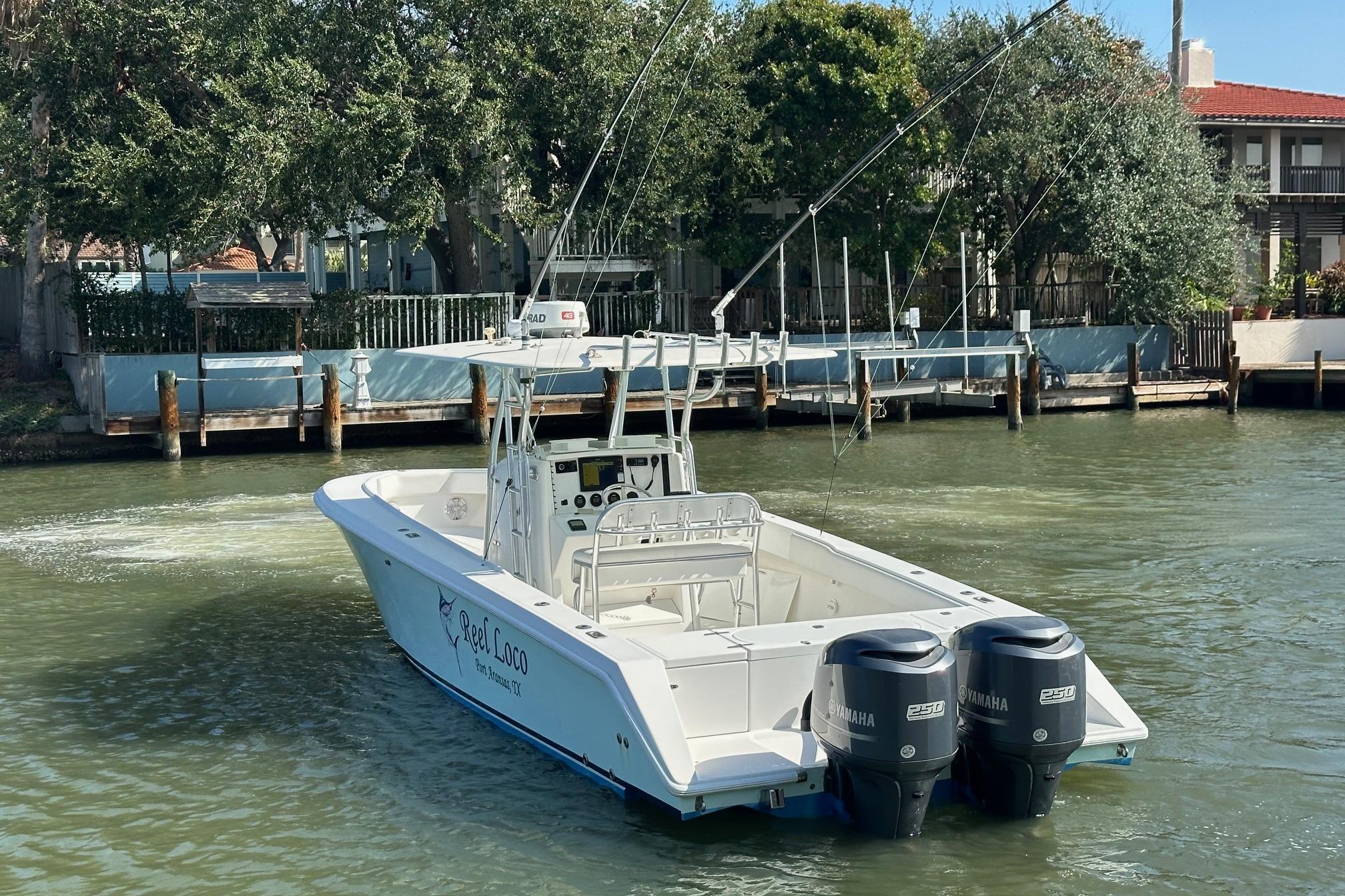 2003 Venture 34 Center Console boat with dual Yamaha engines on a calm waterway.