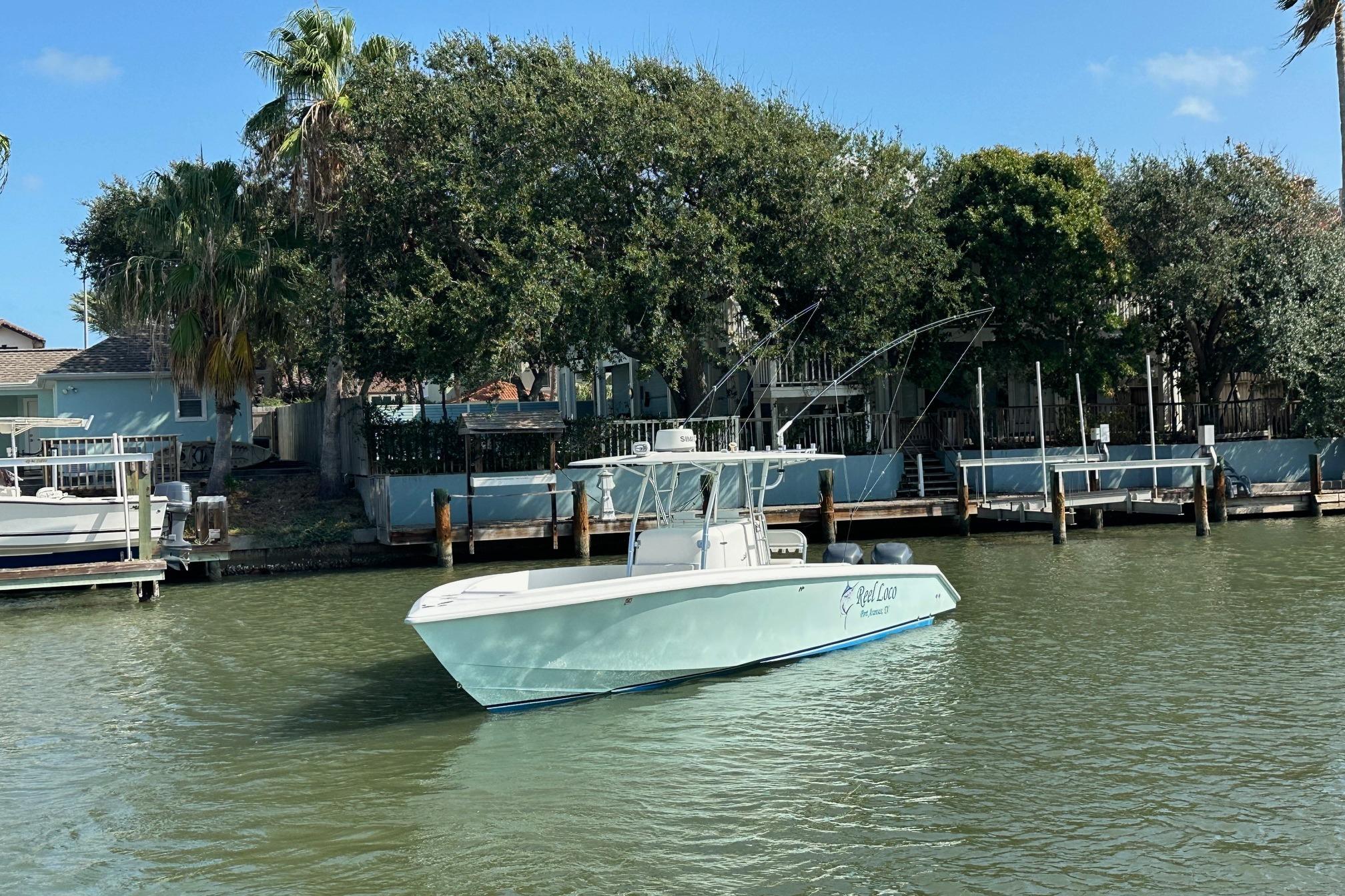 2003 Venture 34 Center Console boat docked on a calm waterfront.