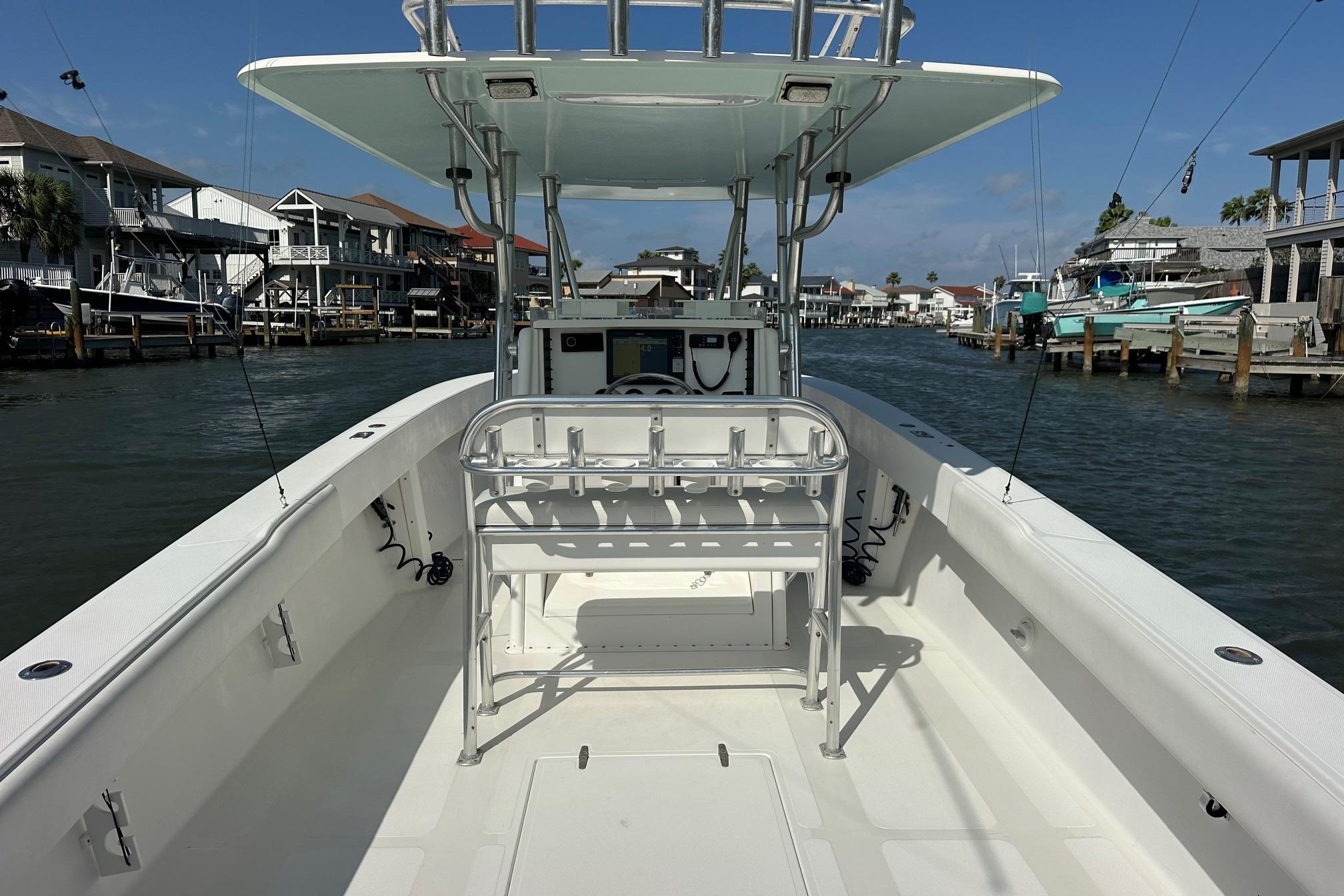 2003 Venture 34 Center Console boat on a calm waterway, surrounded by waterfront homes.
