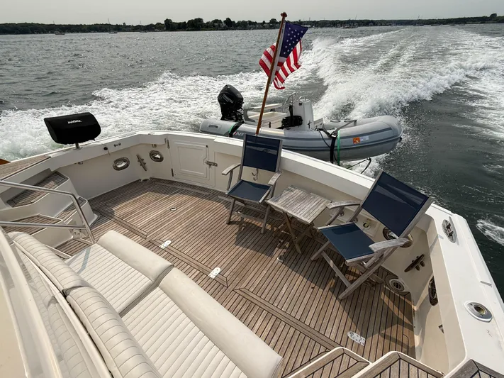 Bira Yacht Photos Pics 2006 Grand Banks 49 Eastbay SX yacht with spacious deck, chairs, and American flag.