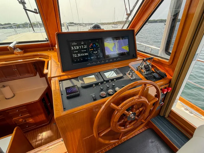 Bira Yacht Photos Pics 2006 Grand Banks 49 Eastbay SX helm with navigation screens and wooden steering wheel.