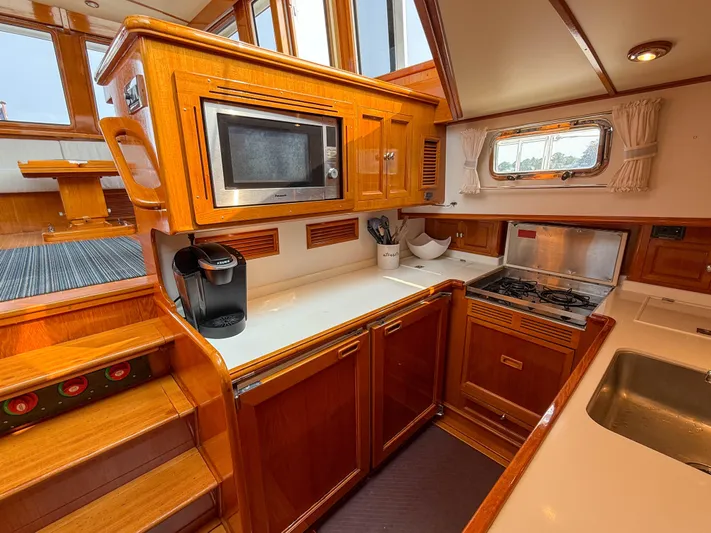 Bira Yacht Photos Pics Luxurious 2006 Grand Banks 49 Eastbay SX yacht kitchen with wood cabinetry and modern appliances.