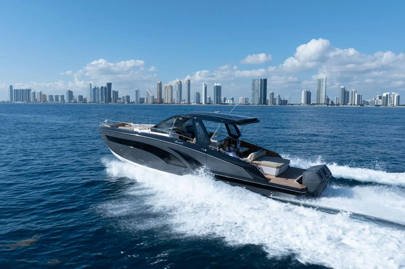 2026 Hanover 447 yacht cruising near city skyline under clear blue sky.