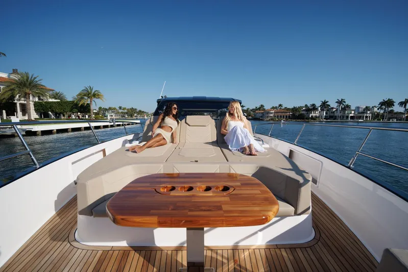  Yacht Photos Pics Luxury Hanover 447 yacht, 2026 model, with two women relaxing on deck, scenic waterfront view.