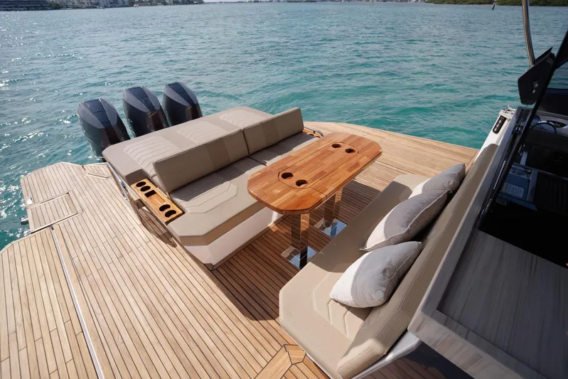  Yacht Photos Pics Luxurious Hanover 447 yacht deck with seating, table, and triple engines on clear water.
