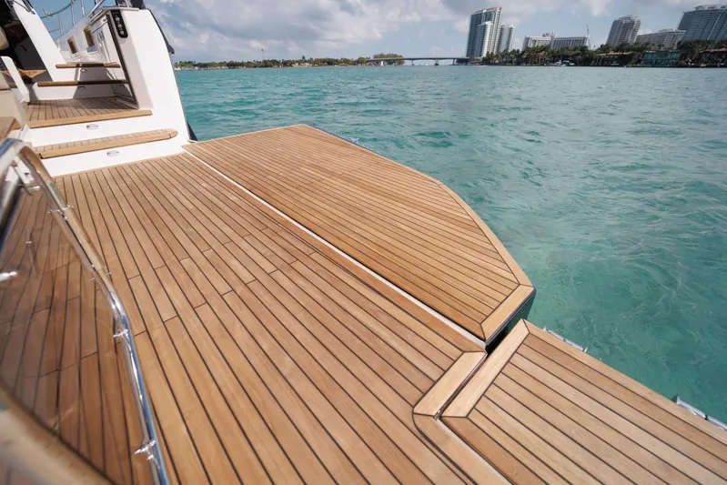  Yacht Photos Pics Luxurious Hanover 447 yacht deck, 2026 model, overlooking turquoise waters and city skyline.