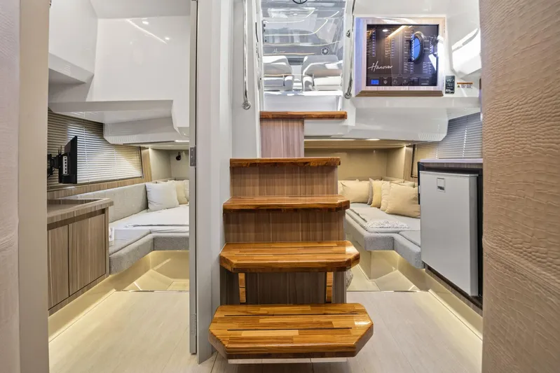  Yacht Photos Pics Luxurious interior of 2026 Hanover 447 yacht with wooden stairs and cozy seating area.