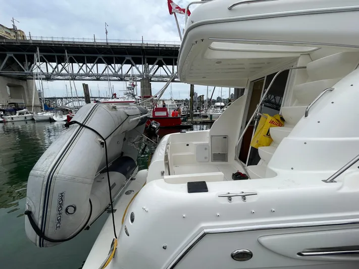 Queen Alexia Yacht Photos Pics 2005 Meridian 341 Sedan yacht with inflatable boat docked near a bridge.