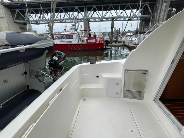 Queen Alexia Yacht Photos Pics 2005 Meridian 341 Sedan boat deck near docked rescue vessel under bridge.