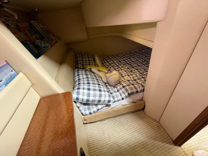 Queen Alexia Yacht Photos Pics Cozy cabin interior of 2005 Meridian 341 Sedan with plaid bedding and books.