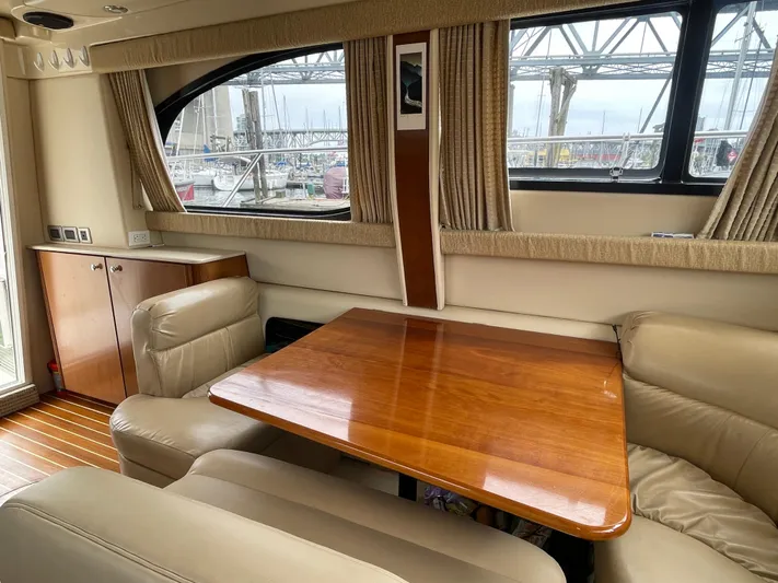 Queen Alexia Yacht Photos Pics Interior of a 2005 Meridian 341 Sedan yacht with leather seating and wooden table.
