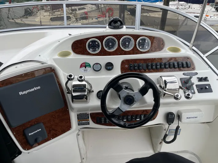 Queen Alexia Yacht Photos Pics Control panel of a 2005 Meridian 341 Sedan boat with steering wheel and navigation instruments.