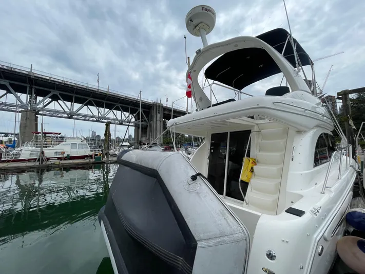 Queen Alexia Yacht Photos Pics 2005 Meridian 341 Sedan yacht docked near a bridge on a cloudy day.