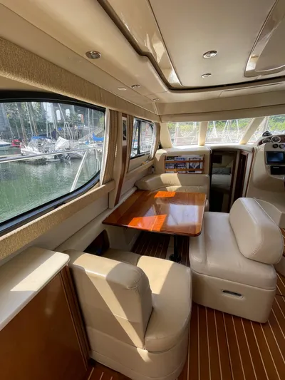 Queen Alexia Yacht Photos Pics Interior of 2005 Meridian 341 Sedan yacht with elegant seating and wooden table.