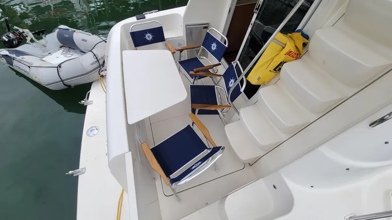 Queen Alexia Yacht Photos Pics 2005 Meridian 341 Sedan yacht deck with chairs, table, and inflatable boat.