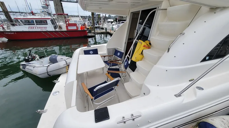 Queen Alexia Yacht Photos Pics 2005 Meridian 341 Sedan yacht with seating area, docked near rescue boats.
