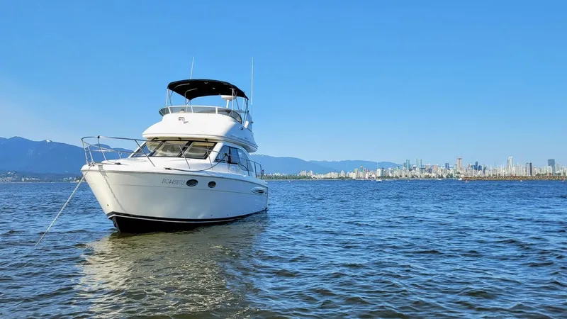 Queen Alexia Yacht Photos Pics 2005 Meridian 341 Sedan yacht on calm water with city skyline in background.