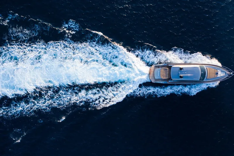 Pax Yacht Photos Pics Aerial view of 2008 Pershing 64 yacht cruising on open sea, leaving a white wake.