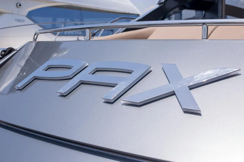 Pax Yacht Photos Pics Close-up of 2008 Pershing 64 yacht with 'PAX' emblem on metallic surface.