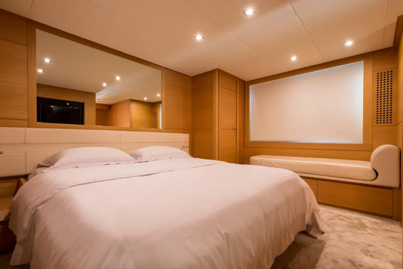 Pax Yacht Photos Pics Luxurious bedroom interior on 2008 Pershing 64 yacht, featuring elegant wood paneling and ambient lighting.
