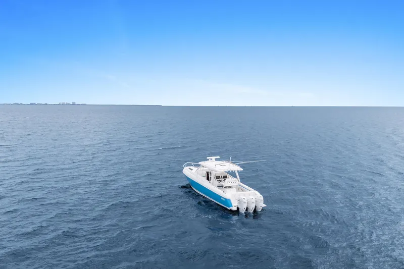  Yacht Photos Pics 2018 Intrepid 407 Cuddy boat cruising on open ocean under clear blue sky.