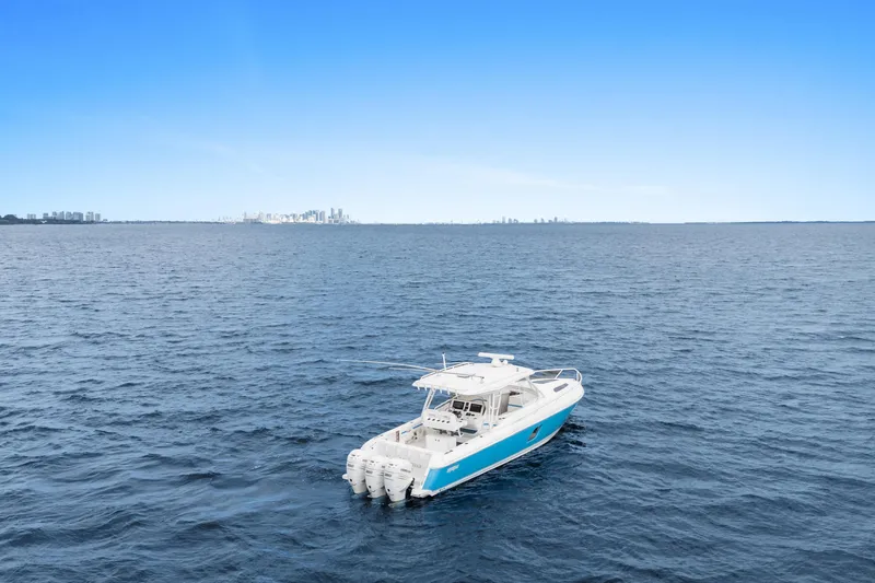  Yacht Photos Pics 2018 Intrepid 407 Cuddy boat on open sea with city skyline in background.