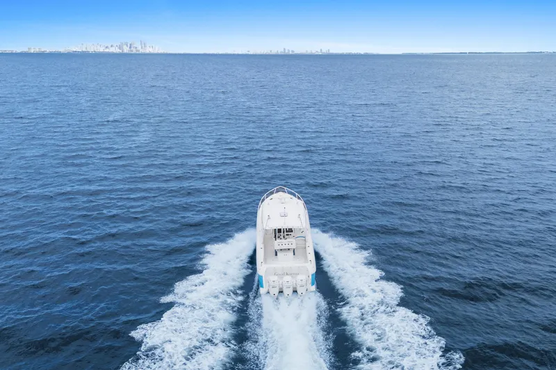  Yacht Photos Pics 2018 Intrepid 407 Cuddy cruising on open ocean with city skyline in background.