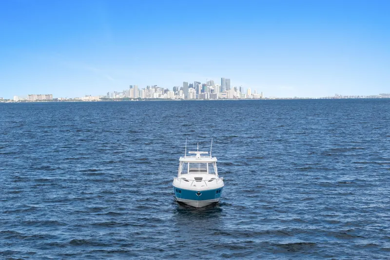  Yacht Photos Pics 2018 Intrepid 407 Cuddy boat on open water with city skyline backdrop.