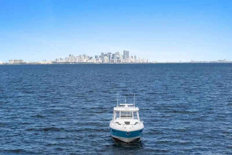  Yacht Photos Pics 2018 Intrepid 407 Cuddy boat on open water with city skyline in background.