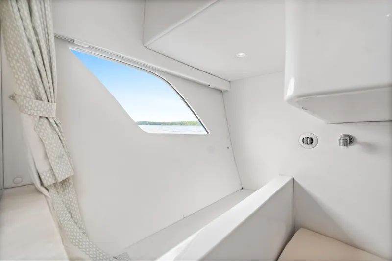  Yacht Photos Pics Interior of 2018 Intrepid 407 Cuddy boat, featuring a window and curtain.