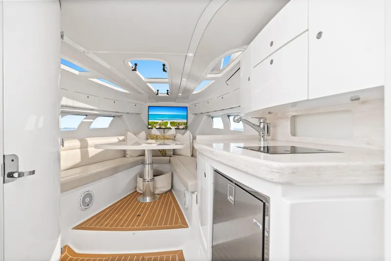  Yacht Photos Pics Luxurious interior of 2018 Intrepid 407 Cuddy boat with modern kitchen and seating area.