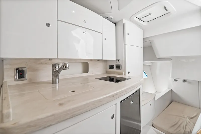  Yacht Photos Pics 2018 Intrepid 407 Cuddy interior with modern kitchen and sleek white cabinetry.