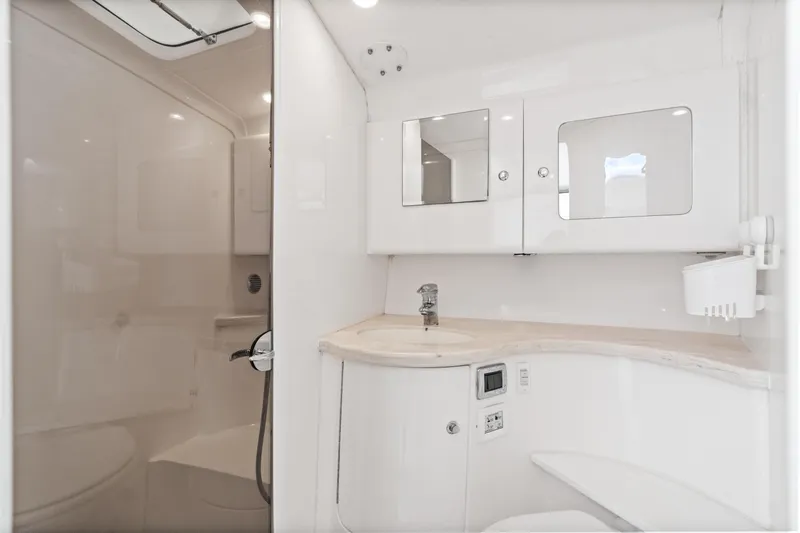  Yacht Photos Pics Luxurious bathroom interior of 2018 Intrepid 407 Cuddy boat, featuring sleek white design.