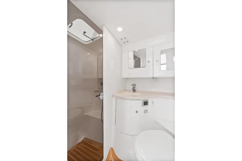  Yacht Photos Pics 2018 Intrepid 407 Cuddy boat bathroom with modern fixtures and white cabinetry.