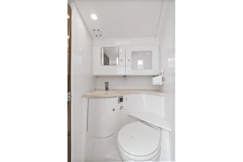  Yacht Photos Pics 2018 Intrepid 407 Cuddy boat bathroom with modern fixtures and white cabinetry.