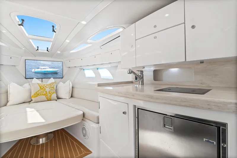  Yacht Photos Pics Luxurious interior of 2018 Intrepid 407 Cuddy boat with modern kitchenette and seating area.