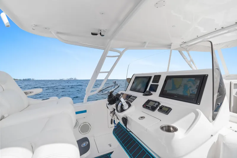  Yacht Photos Pics 2018 Intrepid 407 Cuddy boat helm with navigation screens, steering wheel, and ocean view.